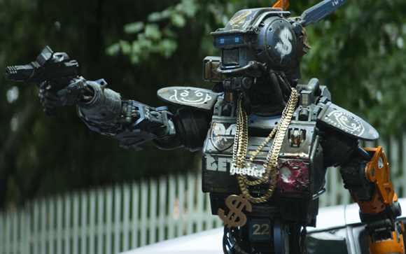A combat robot with gold chains, a dollar sign emblem, and a gun pointed to the left.