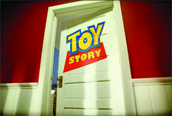 The Toy Story logo is displayed on a white paneled door set against a red wall.