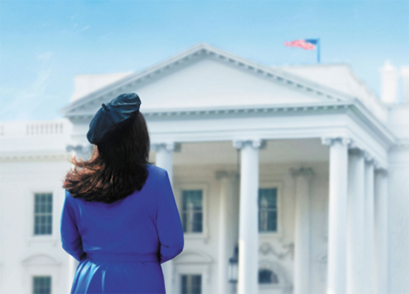 A woman with dark hair wearing a blue dress and black hat stands facing the White House.
