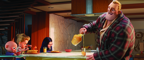 A large man in a plaid robe pours orange juice from a pitcher for a family sitting at a kitchen counter.