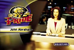 A news anchor sits at a desk next to a large 'PRIDE' graphic featuring a lion logo.