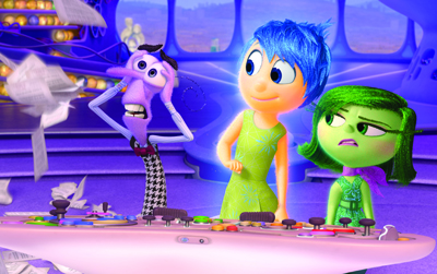 Animated characters Joy, Sadness, and Fear stand in a brightly colored, whimsical room.
