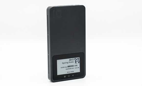 A black rectangular external hard drive with a small screen displaying text and a progress bar.