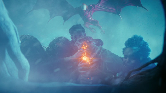 People huddle in a blue mist while a large, dark winged creature flies overhead.