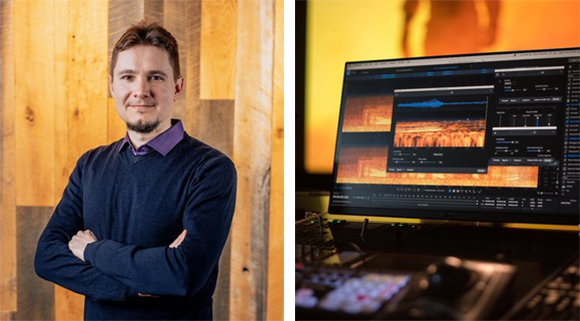 A man with arms crossed stands by a computer monitor showing video editing software.