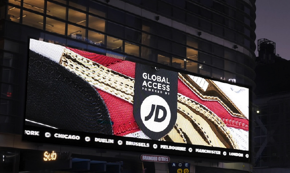 Large digital billboard on a building displaying a JD Global Access advertisement with a red and gold pattern.