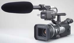 A black JVC video camera equipped with a large, black shotgun microphone on top.