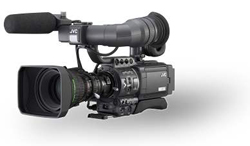 A black JVC professional video camera with a large lens, microphone, and viewfinder against a white background.