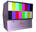 A gray JVC electronic device displaying a multicolored SMPTE-style test pattern on its screen.