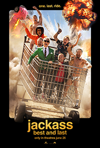 A group of men crowded into a large metal shopping cart amidst dust and a massive explosion.