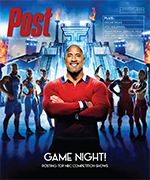 Dwayne Johnson in a red sweater stands with contestants in athletic wear in front of a large, illuminated obstacle course.