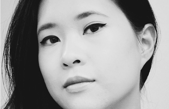 Black and white close-up of a woman with dark hair and winged eyeliner looking toward the camera.