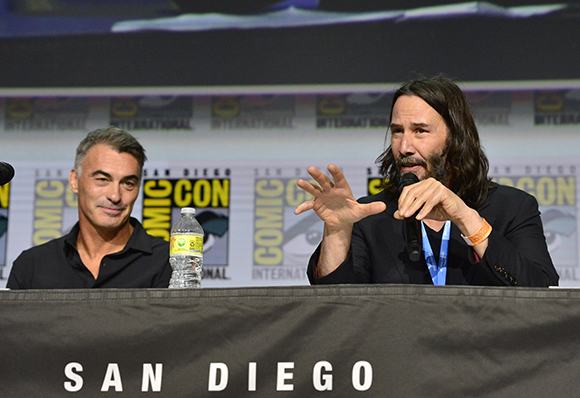 Two men sit behind a table with a San Diego sign during a panel discussion.