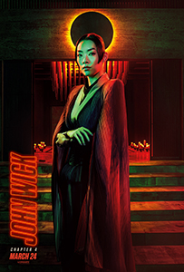 A woman in a dark suit and long coat stands before a glowing orange halo and red-lit background.