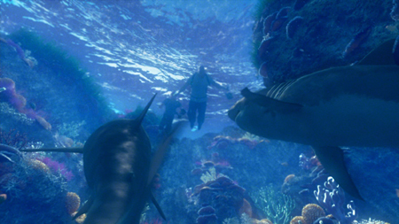 A person swims through deep blue water surrounded by large fish and colorful coral reefs.