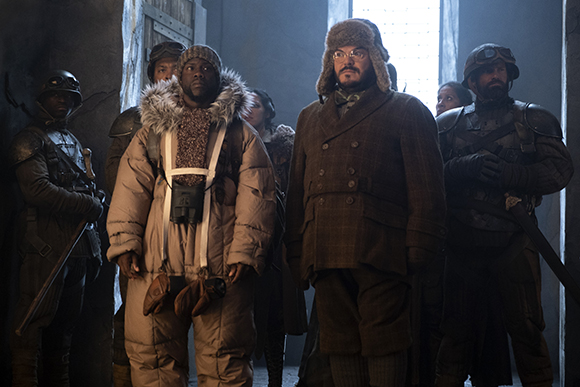 A group of people in heavy winter clothing and military uniforms standing in a dimly lit doorway.