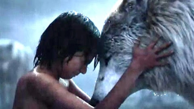 A young child with dark hair leans forward to touch foreheads with a large, grey and white wolf.