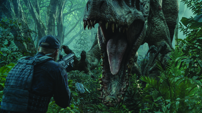 A man in tactical gear aims a rifle at a large dinosaur with its mouth wide open in a dense jungle.