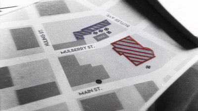 A close-up, angled shot of a printed street map showing Mulberry St., Main St., and Huling St. with colored shapes.