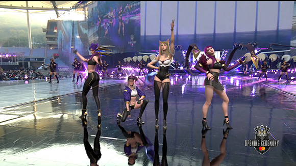 Animated female performers in stylized outfits pose on a large, reflective stage during a concert event.