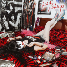 Person in KISS face paint and black tank top lying on a red tiger-print bed amidst makeup and posters.