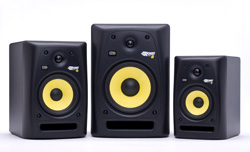 Three black speakers with yellow drivers arranged from smallest to largest against a white background.