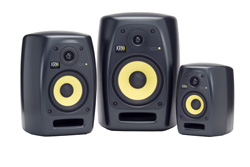 Three black studio monitor speakers with yellow drivers arranged in increasing size from right to left.