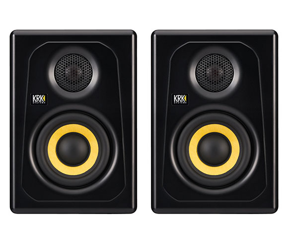 Two black KRK studio monitors with yellow-rimmed woofers against a white background.