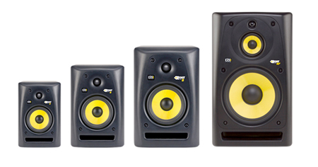 Four black studio monitors arranged from smallest to largest against a white background.
