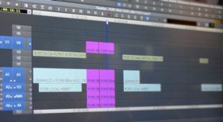 Video editing timeline with audio and video tracks, showing text labels and colored clips.