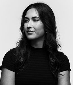 Black and white portrait of a woman with long wavy hair looking off-camera.