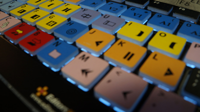 Close-up view of colorful, backlit mechanical keyboard keys in yellow, blue, red, and white.