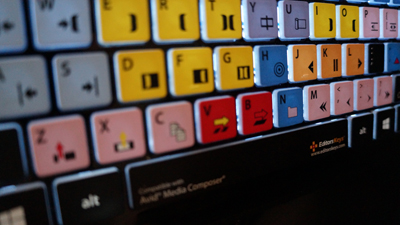 Close-up view of a computer keyboard with colorful, color-coded keycaps in yellow, blue, red, and pink.