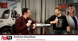 A man in a maroon shirt interviews a man in a black sweatshirt in a studio.