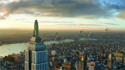 Aerial cityscape at sunset with a tall skyscraper in the foreground and flying objects over a river.