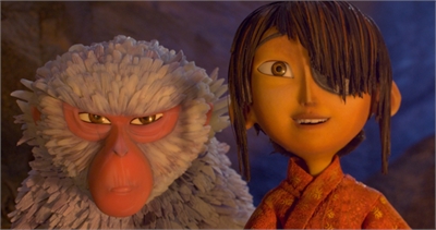 Close-up of a stylized monkey with white fur and a red face next to a young boy with dark hair and an orange tunic.