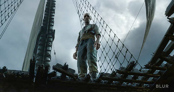 A man in rugged clothing stands on the deck of a large sailing ship under a cloudy sky.