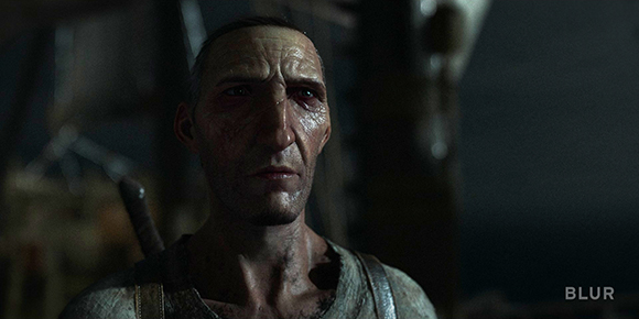 Close-up of a man with short dark hair and visible scars on his face looking forward.