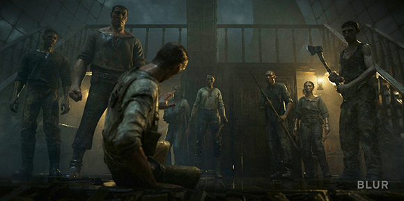 A group of men stand in a circle around a kneeling man in a dimly lit, industrial room.