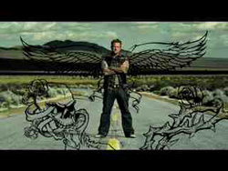 A man stands with arms crossed, overlaid with large black wings and skull illustrations against a desert landscape.