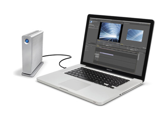 A silver laptop connected via cable to a vertical silver external hard drive on a white background.