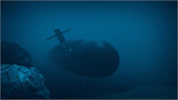 A dark submarine silhouette moving through deep blue water near rocky terrain.