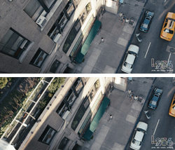 Aerial view of a city street with parked cars, a yellow taxi, and pedestrians walking near a building.