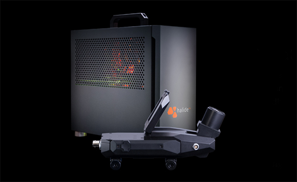 A black electronic device with the Halide logo sits in front of a larger black rectangular unit.