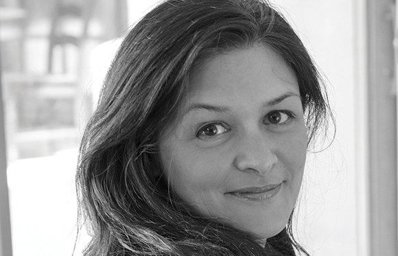 Black and white close-up portrait of a woman looking toward the camera with a slight smile.