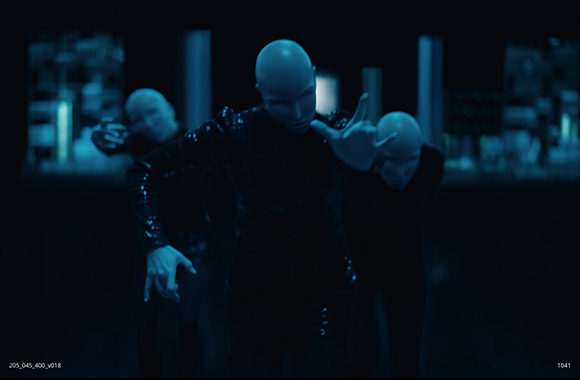 Three figures wearing dark outfits and smooth white masks pose in a dimly lit, blue-toned environment.