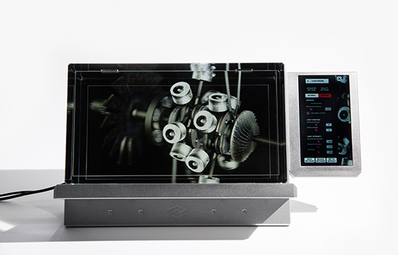 A digital screen displaying a close-up of mechanical gears next to a vertical control panel.