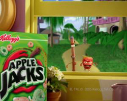 A box of Apple Jacks cereal sits in front of a window showing a tropical cartoon landscape with characters.