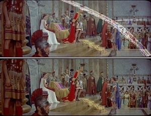 Characters in Roman attire stand in a grand palace hall with marble columns and onlookers.