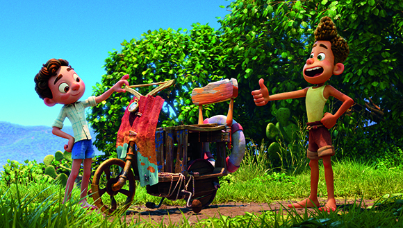 Two animated boys stand by a wooden, makeshift vehicle on a sunny path near lush green bushes.
